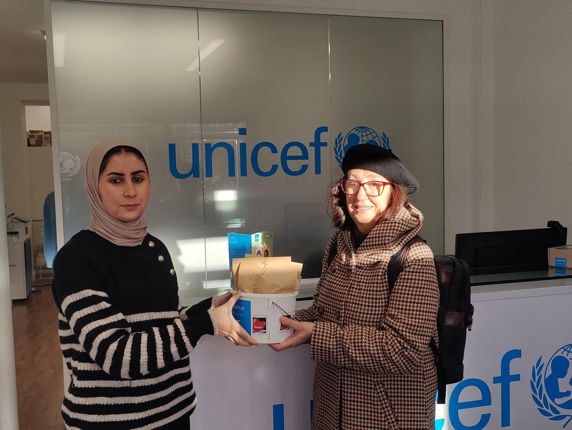 Prof Isabel Rozas hands over the cash raised at our coffeee morning to a UNICEF representative